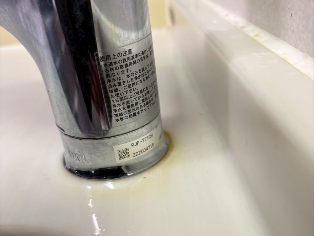 キッチン水栓の根元に貼られた品番ラベルの例。RJF-771CHと書かれている